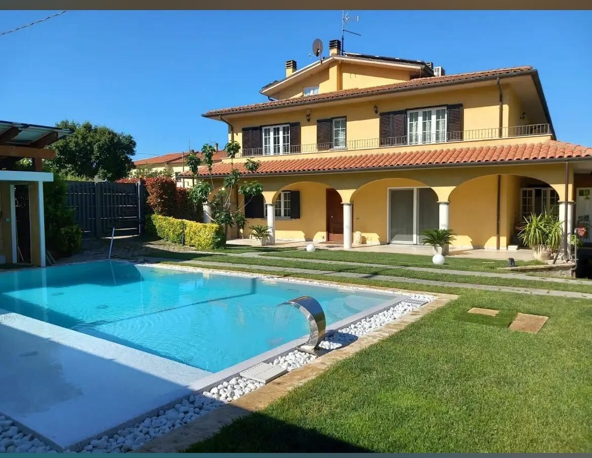 Facciata della villa con piscina e giardino
