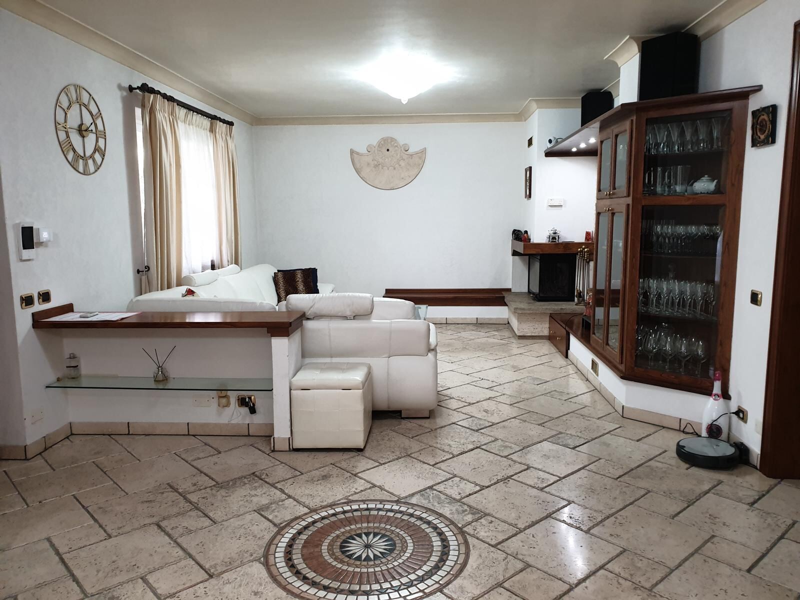 Soggiorno con camino e pavimento in travertino