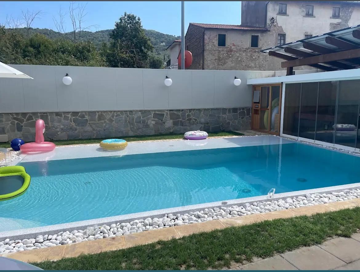 Piscina con vista collinare e giochi gonfiabili